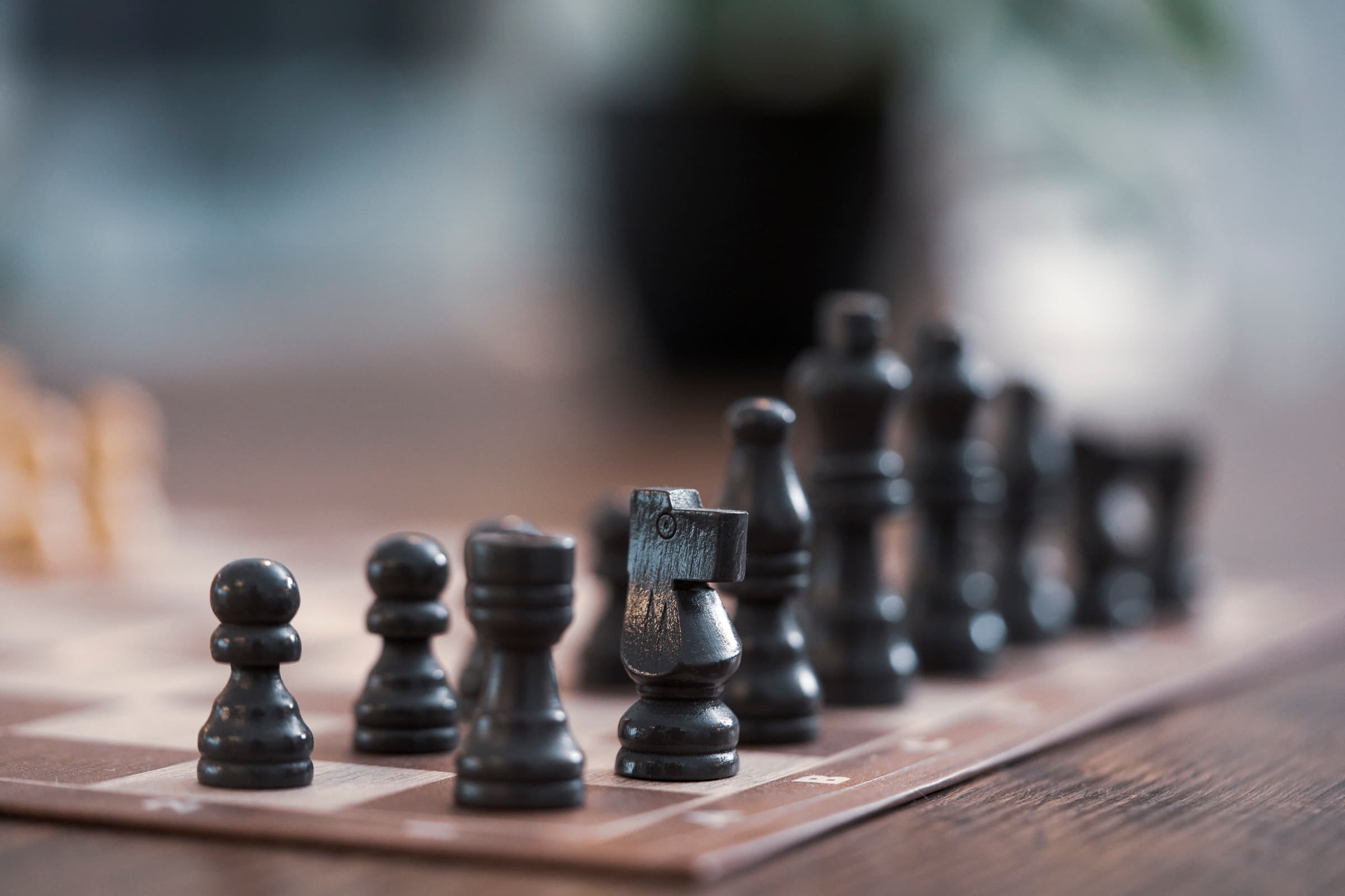 Close-up of black chess pieces on an office desk