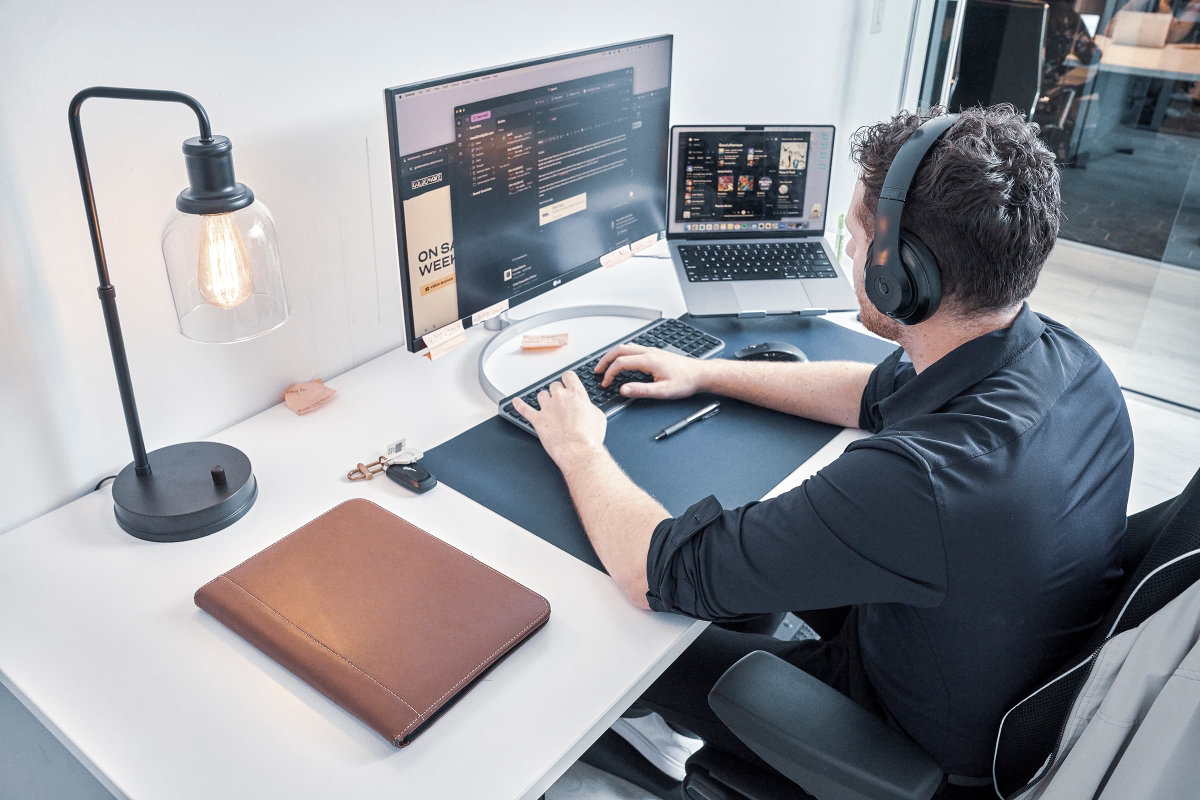 Man focused on work across dual screens