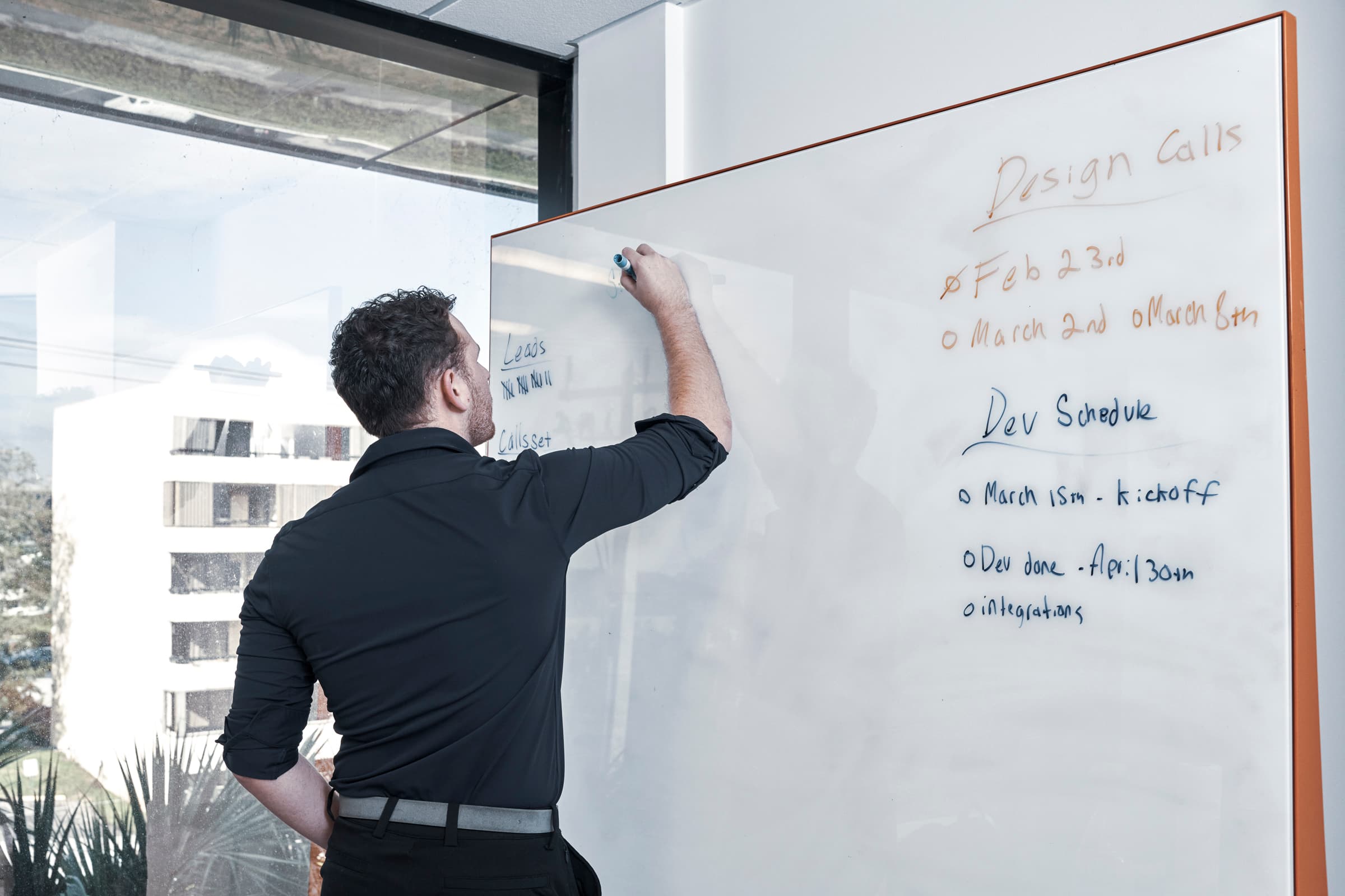 Man writing on a whiteboard during a brainstorming session